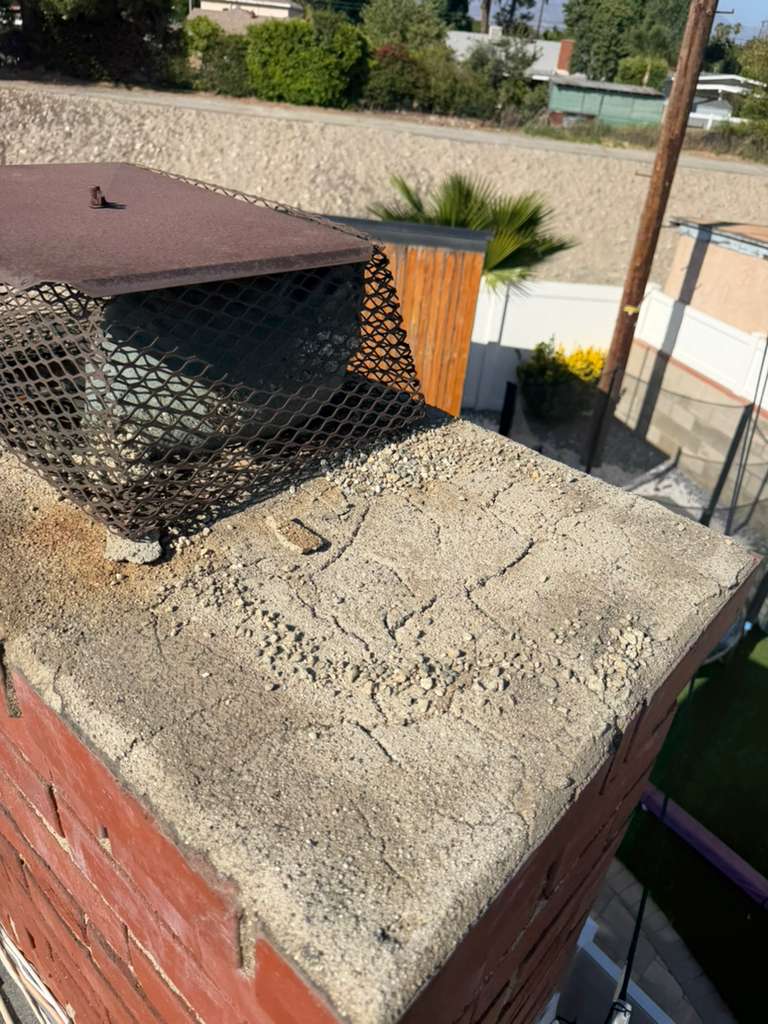 Old rusted undersized chimney cap before replacement