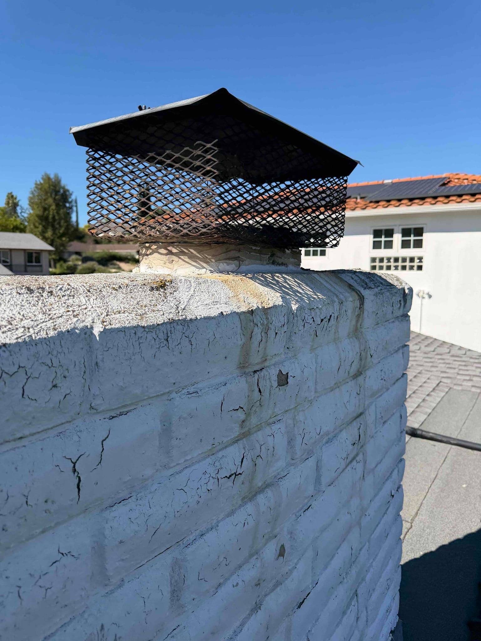 Deteriorated chimney cap before replacement showing rust and damage