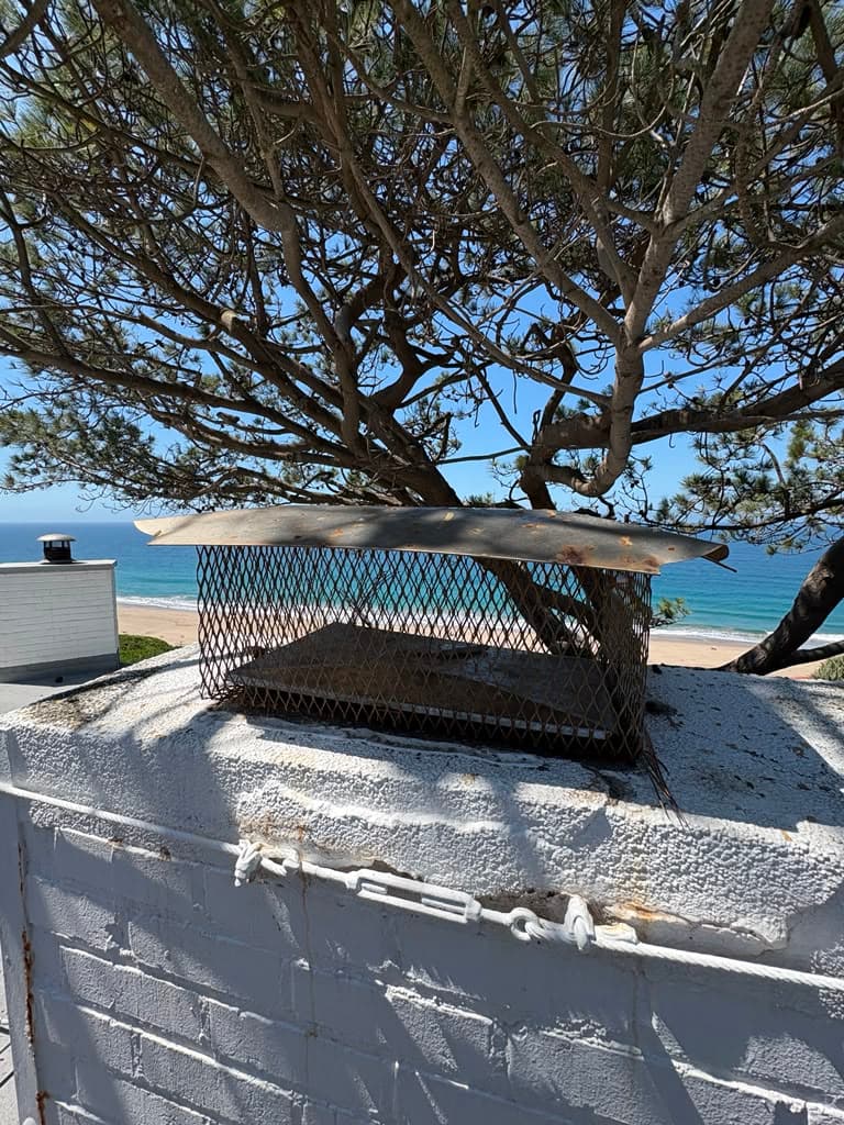 Chimney with an open flue and a worn damper before replacement