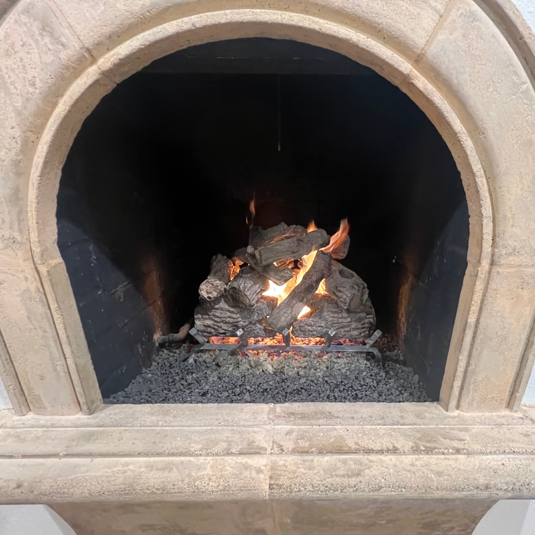 Realistic gas log set installed in a brick fireplace with warm flame pattern